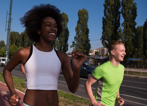 multiethnic group of young people on the jogging beautiful morning as the sun rises in the streets of the city