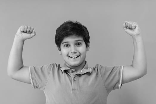 Portrait of a happy young boy in front of colored background