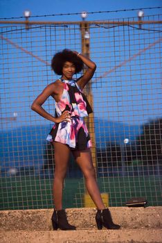 portrait of a young beautiful African American women on a warm summer night  in colorful dress with a smile on her face