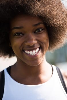 Close up portrait of a beautiful young african american woman smiling and looking up on a beautiful sunny day