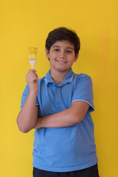 Portrait of a young boy painter with a brush in his hand in front of colored background