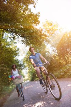 a young man and a beautiful African American girl enjoying a bike ride in nature on a sunny summer day