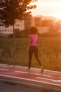 young beautiful African American woman enjoys running outside beautiful summer evening in the city