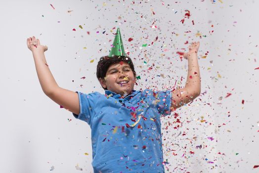 Happy kid celebrating party with blowing confetti