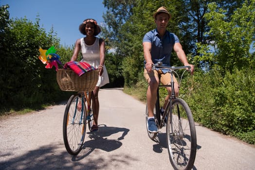 a young man and a beautiful African American girl enjoying a bike ride in nature on a sunny summer day