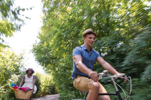 a young man and a beautiful African American girl enjoying a bike ride in nature on a sunny summer day