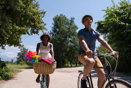 a young man and a beautiful African American girl enjoying a bike ride in nature on a sunny summer day