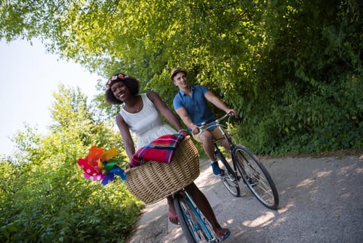 a young man and a beautiful African American girl enjoying a bike ride in nature on a sunny summer day