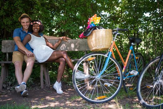 a young man and a beautiful African American girl enjoying a bike ride in nature on a sunny summer day