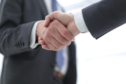 close up.strong handshake of business people.isolated on light background