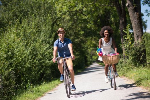 a young man and a beautiful African American girl enjoying a bike ride in nature on a sunny summer day