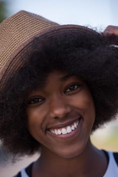 Close up portrait of a beautiful young african american woman smiling and looking up on a beautiful sunny day