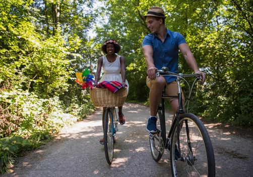 a young man and a beautiful African American girl enjoying a bike ride in nature on a sunny summer day