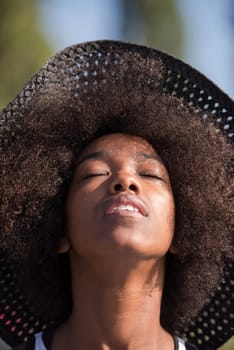 Close up portrait of a beautiful young african american woman smiling and looking up on a beautiful sunny day