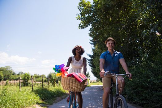 a young man and a beautiful African American girl enjoying a bike ride in nature on a sunny summer day