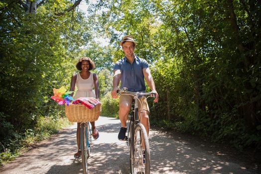 a young man and a beautiful African American girl enjoying a bike ride in nature on a sunny summer day