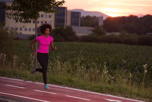 young beautiful African American woman enjoys running outside beautiful summer evening in the city