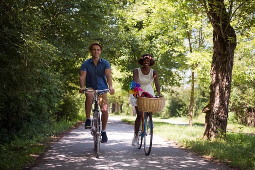 a young man and a beautiful African American girl enjoying a bike ride in nature on a sunny summer day