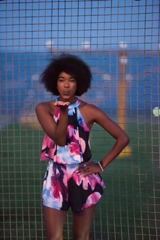 portrait of a young beautiful African American women on a warm summer night  in colorful dress with a smile on her face