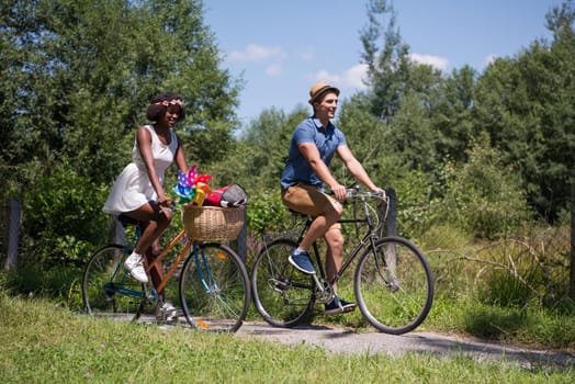 a young man and a beautiful African American girl enjoying a bike ride in nature on a sunny summer day