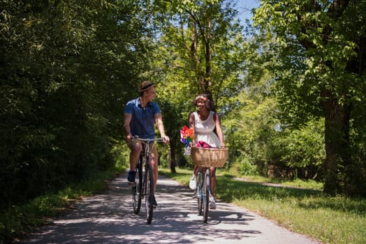 a young man and a beautiful African American girl enjoying a bike ride in nature on a sunny summer day