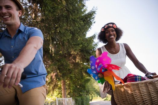 a young man and a beautiful African American girl enjoying a bike ride in nature on a sunny summer day