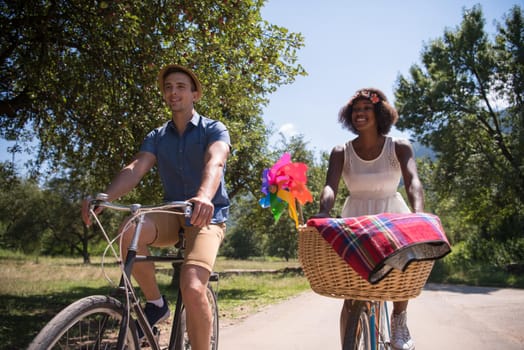 a young man and a beautiful African American girl enjoying a bike ride in nature on a sunny summer day