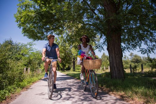 a young man and a beautiful African American girl enjoying a bike ride in nature on a sunny summer day