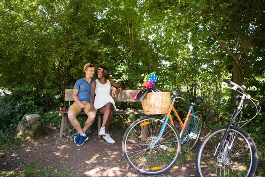 a young man and a beautiful African American girl enjoying a bike ride in nature on a sunny summer day