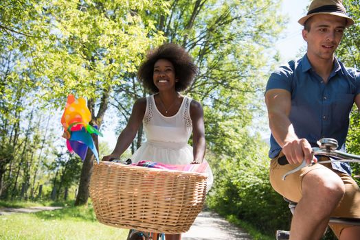 a young man and a beautiful African American girl enjoying a bike ride in nature on a sunny summer day