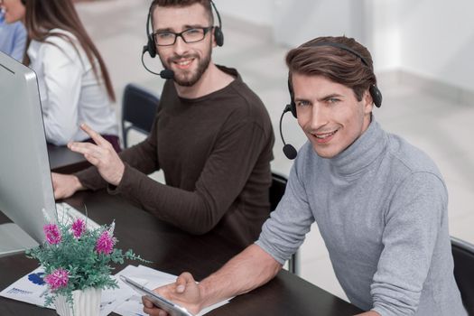 employees of the business center with a headset in the workplace.people and technology
