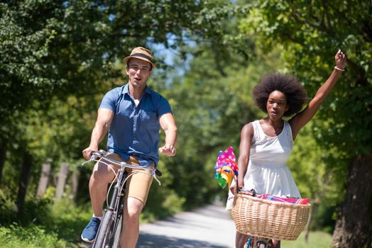 a young man and a beautiful African American girl enjoying a bike ride in nature on a sunny summer day