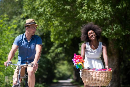 a young man and a beautiful African American girl enjoying a bike ride in nature on a sunny summer day