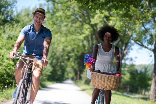 a young man and a beautiful African American girl enjoying a bike ride in nature on a sunny summer day