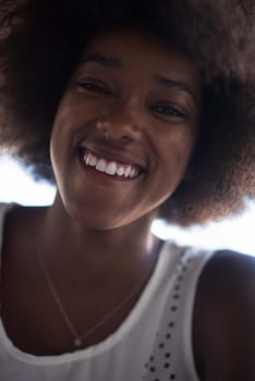 Close up portrait of a beautiful young african american woman smiling and looking up on a beautiful sunny day