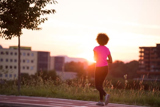 young beautiful African American woman enjoys running outside beautiful summer evening in the city