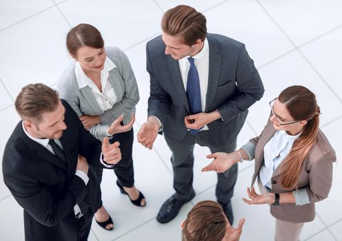 top view.a group of employees talking standing in the office.photo with copy space