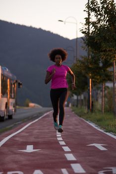 young beautiful African American woman enjoys running outside beautiful summer evening in the city