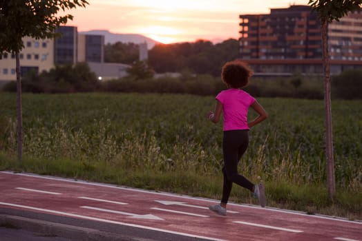 young beautiful African American woman enjoys running outside beautiful summer evening in the city