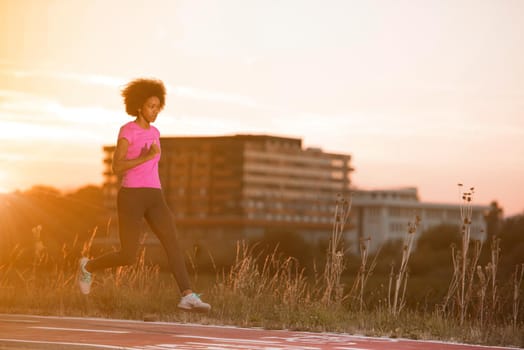 young beautiful African American woman enjoys running outside beautiful summer evening in the city