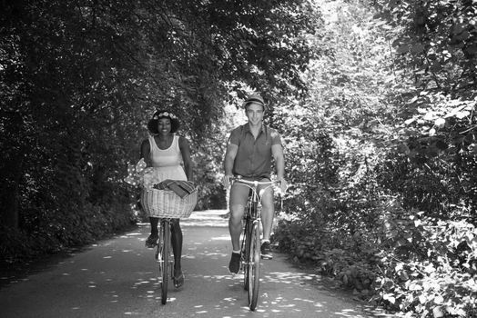 a young man and a beautiful African American girl enjoying a bike ride in nature on a sunny summer day