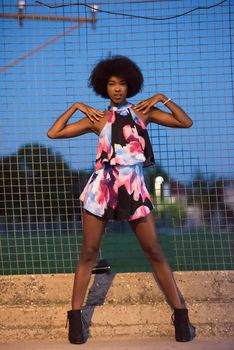 portrait of a young beautiful African American women on a warm summer night  in colorful dress with a smile on her face