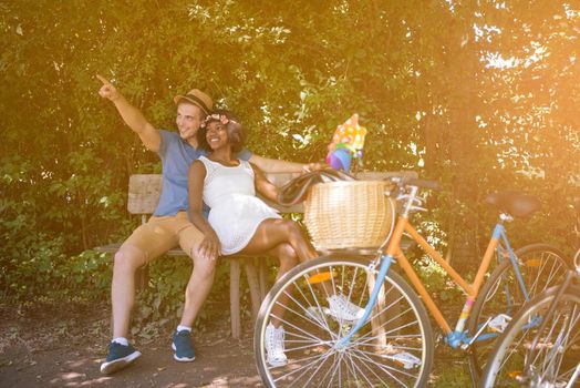 a young man and a beautiful African American girl enjoying a bike ride in nature on a sunny summer day