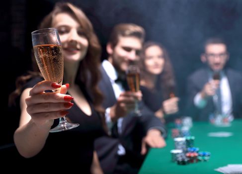 successful fashion woman with glasses of wine,sitting at a table in a casino