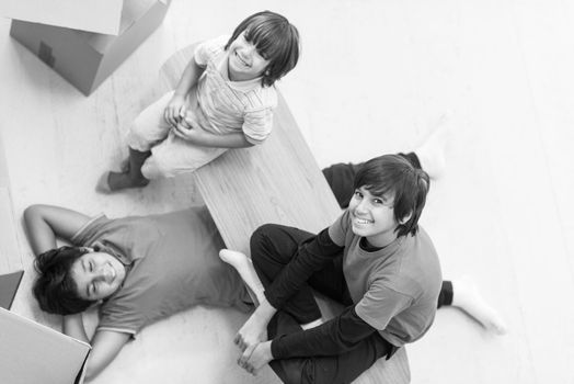 portrait of happy young boys with cardboard boxes around them in a new modern home top view