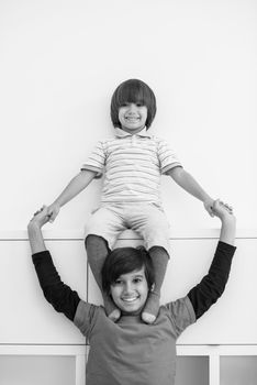 happy young boys having fun and posing line up piggyback in new modern home