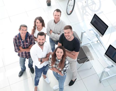 view the top. creative business team standing near the desktop and looking up