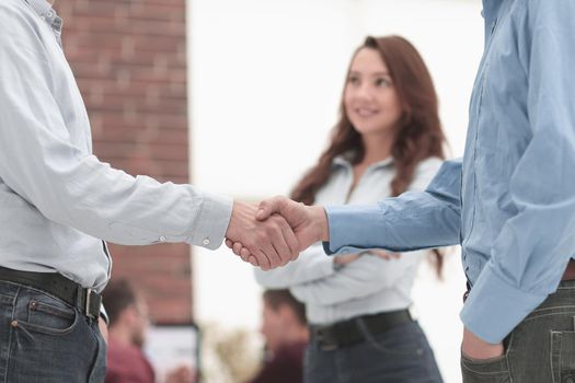 In a sign of cooperation, the partners shake hands after signing.