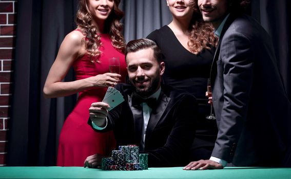 A man, accompanied by a woman, shows four aces in poker