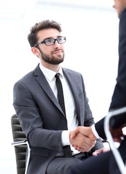 Image of two young businessmen interacting at meeting in office